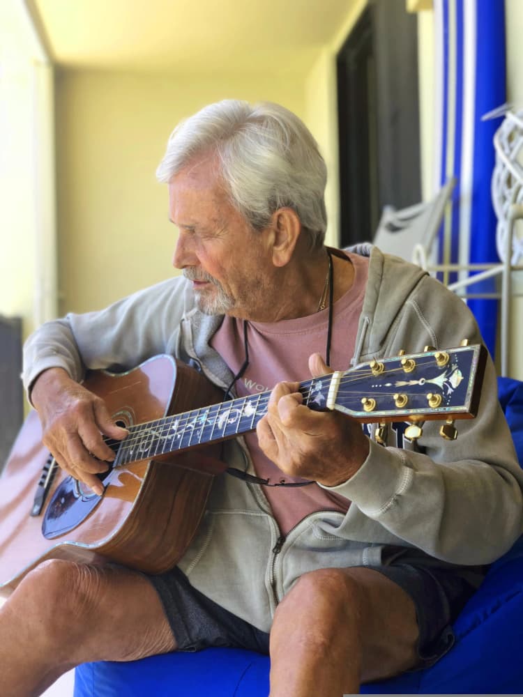 Persona mayor tocando guitarra